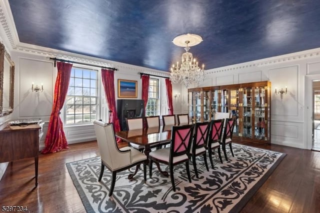 dining area with a notable chandelier, dark hardwood / wood-style flooring, and ornamental molding