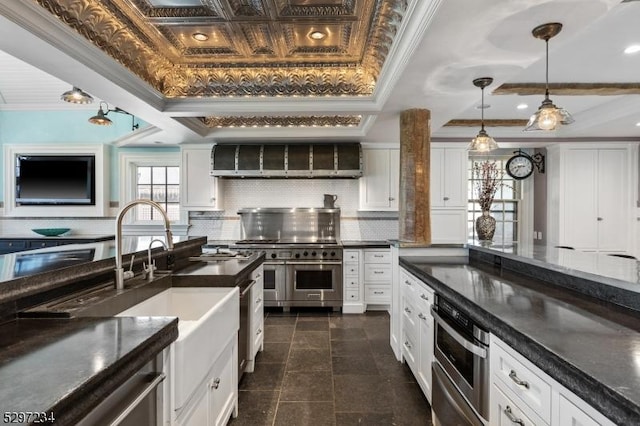 kitchen featuring white cabinets, decorative light fixtures, a raised ceiling, and tasteful backsplash