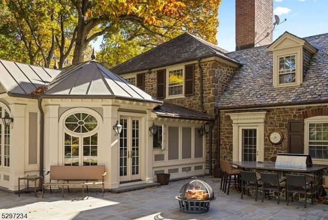 back of property with a patio area, french doors, and an outdoor fire pit