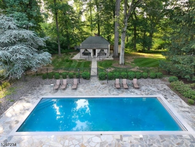 view of pool featuring an outbuilding and a patio