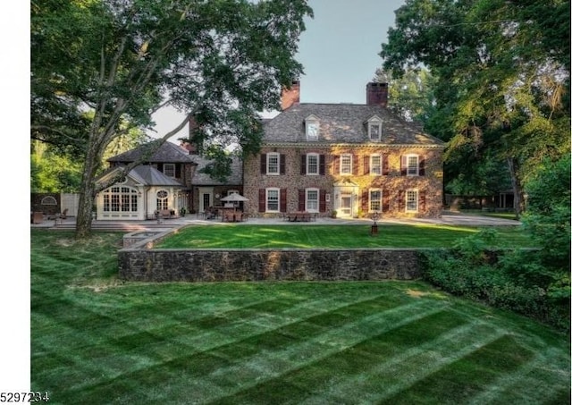 rear view of house with a yard and a patio area