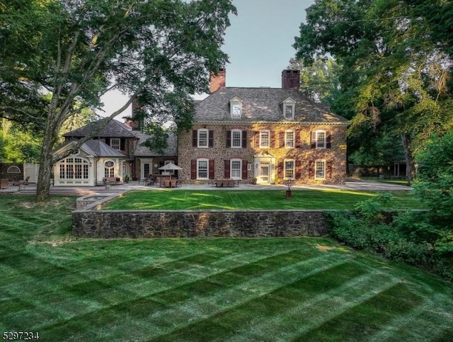 rear view of house featuring a yard and a patio