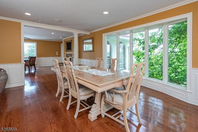 dining room with ornate columns, dark hardwood / wood-style flooring, and ornamental molding