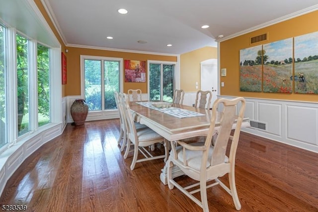 dining space with dark hardwood / wood-style flooring and crown molding