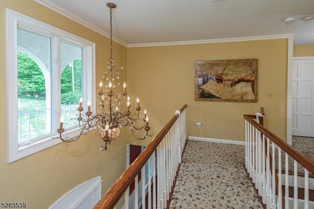 hall featuring crown molding and an inviting chandelier