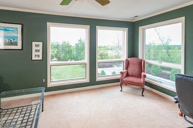 living area with crown molding, carpet floors, and ceiling fan