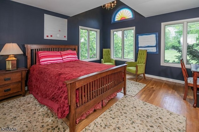 bedroom featuring multiple windows, a chandelier, and wood-type flooring