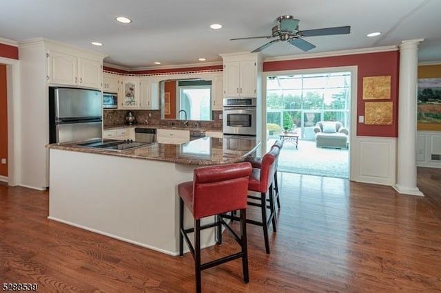 kitchen featuring dark hardwood / wood-style flooring, stainless steel appliances, white cabinetry, and ceiling fan