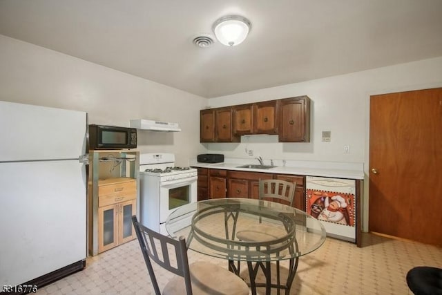 kitchen featuring sink, white appliances, and range hood