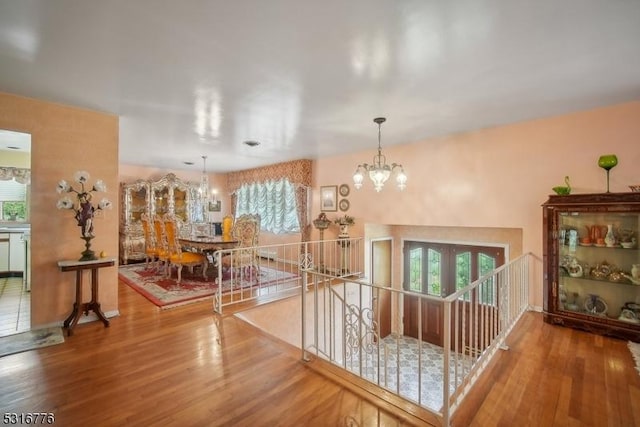 hallway featuring hardwood / wood-style floors and a chandelier