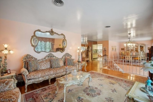 living room with wood-type flooring and an inviting chandelier