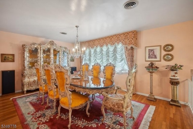 dining area featuring a chandelier and wood-type flooring