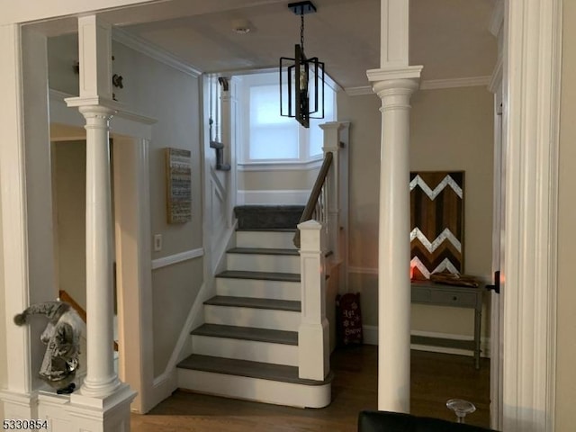 staircase featuring crown molding, a chandelier, and hardwood / wood-style flooring