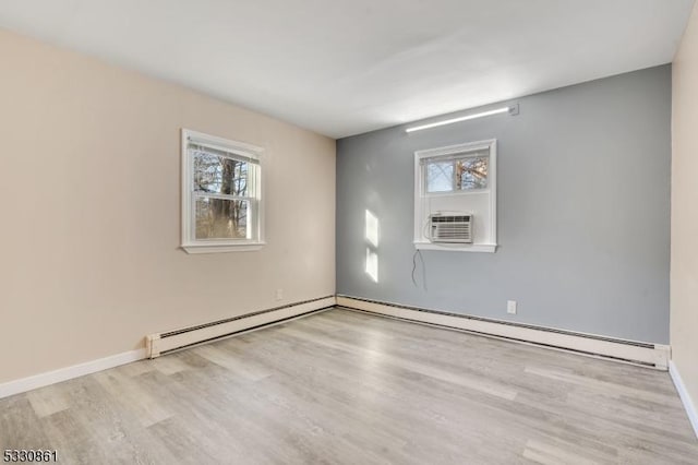 unfurnished room featuring cooling unit, light wood-type flooring, and a baseboard radiator