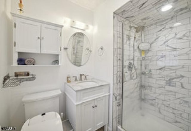 bathroom featuring vanity, toilet, and a shower with door