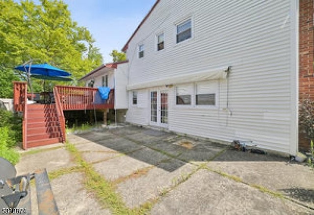 back of property with french doors, a patio, and a deck