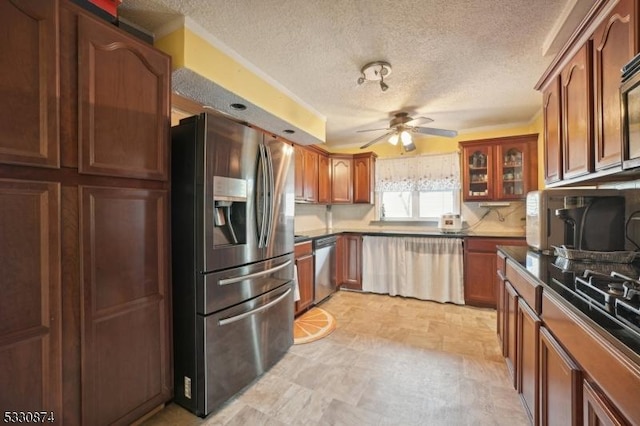 kitchen with a textured ceiling, ceiling fan, and stainless steel appliances