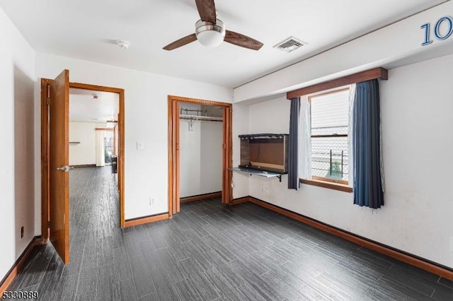 unfurnished bedroom with dark hardwood / wood-style flooring, a closet, and ceiling fan