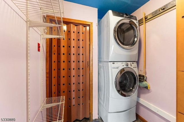 laundry area featuring stacked washer / drying machine