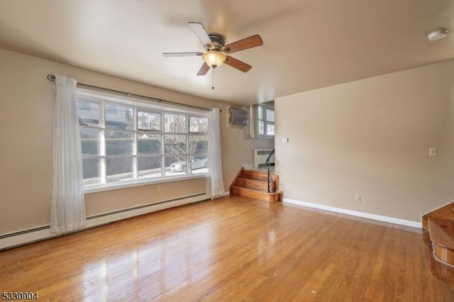 unfurnished living room with ceiling fan, light hardwood / wood-style floors, a wall unit AC, and a baseboard radiator