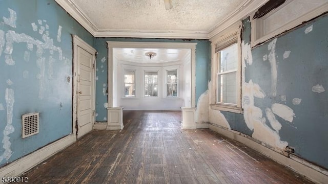 misc room featuring a textured ceiling, ornamental molding, a healthy amount of sunlight, and dark hardwood / wood-style floors