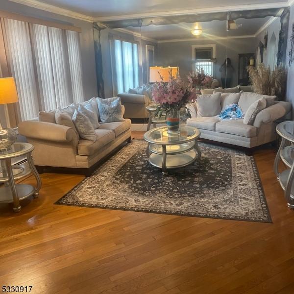 living room with hardwood / wood-style flooring, a wealth of natural light, and crown molding