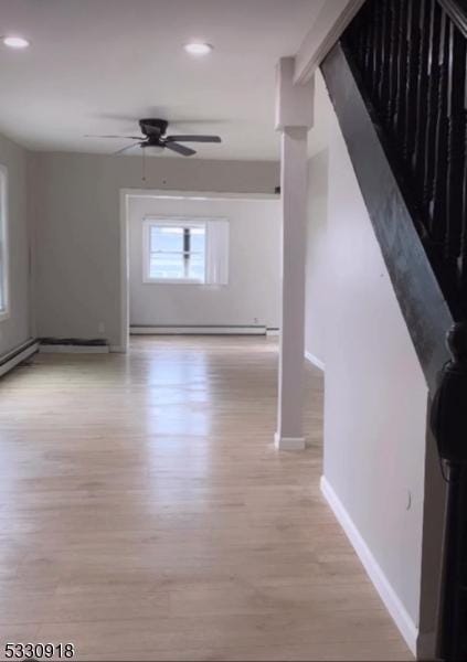 hallway featuring a baseboard heating unit and light hardwood / wood-style flooring