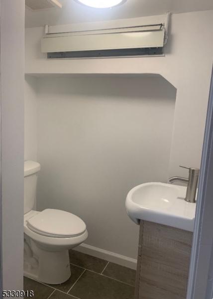 bathroom featuring vanity, tile patterned floors, and toilet