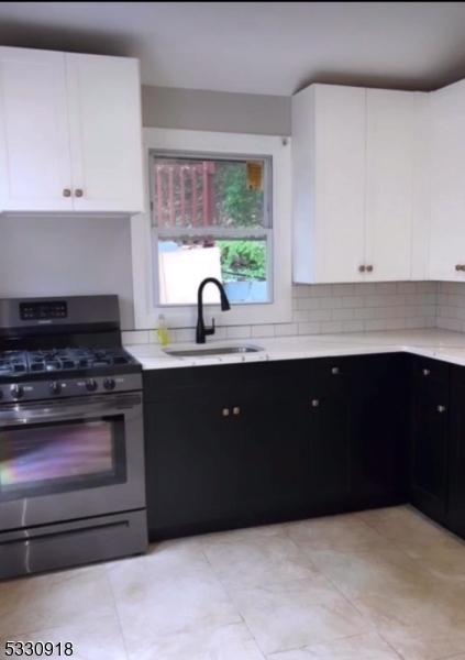 kitchen featuring white cabinetry, sink, and stainless steel gas range