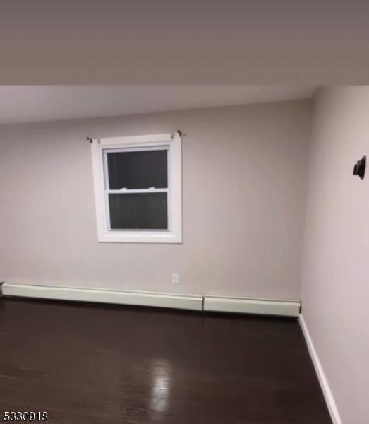 unfurnished room featuring a baseboard heating unit