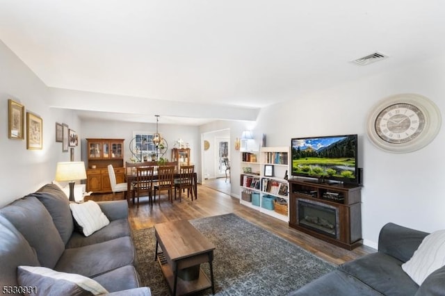 living room with dark hardwood / wood-style flooring and an inviting chandelier