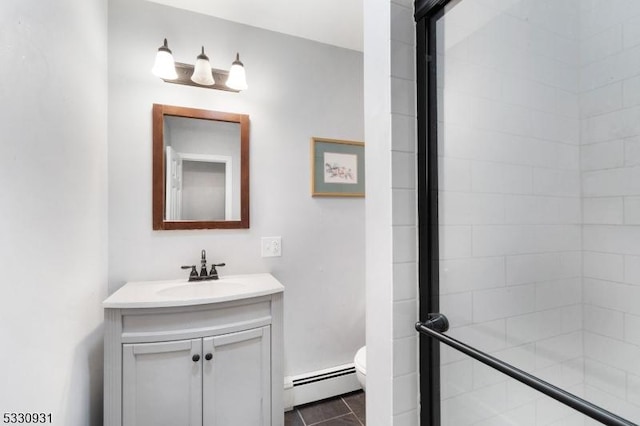 bathroom featuring baseboard heating, tile patterned flooring, vanity, and toilet