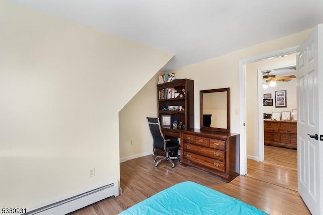 home office with ceiling fan, hardwood / wood-style floors, a baseboard radiator, and vaulted ceiling