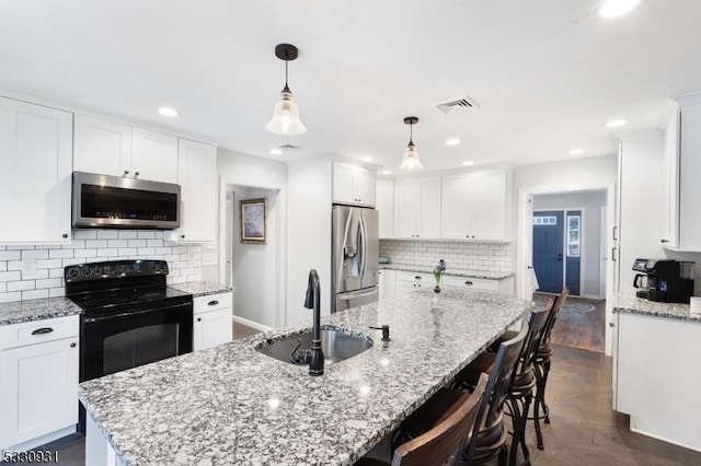 kitchen featuring white cabinets, decorative light fixtures, stainless steel appliances, and sink