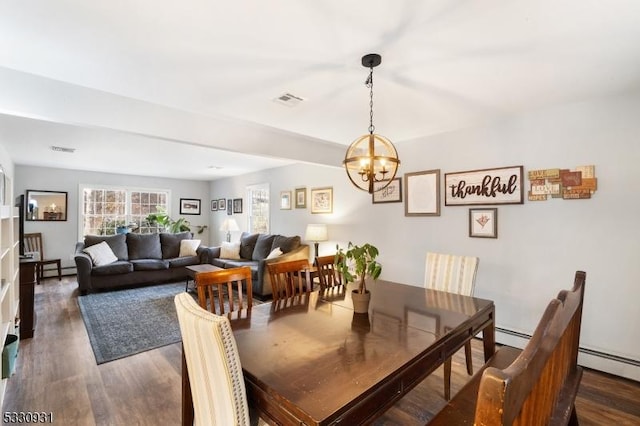 dining room featuring a notable chandelier, dark hardwood / wood-style flooring, and a baseboard heating unit