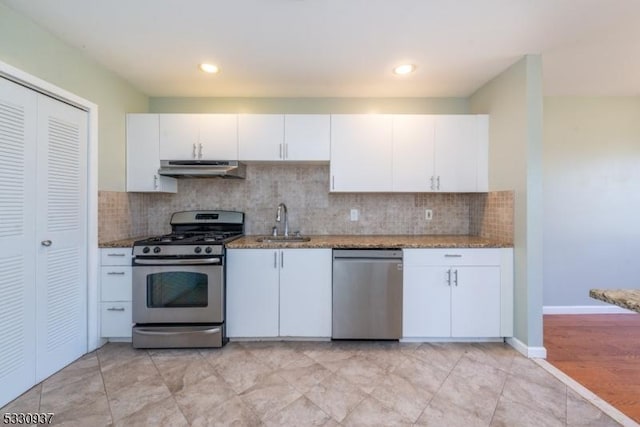 kitchen with sink, white cabinetry, stainless steel appliances, and dark stone countertops