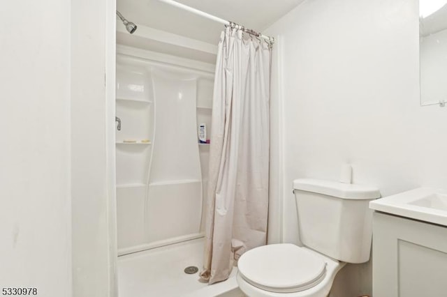 bathroom with toilet, a shower with shower curtain, and vanity