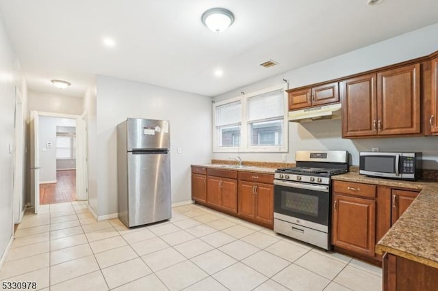 kitchen featuring light tile patterned floors, appliances with stainless steel finishes, and sink