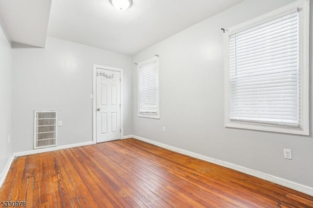 empty room with plenty of natural light and wood-type flooring