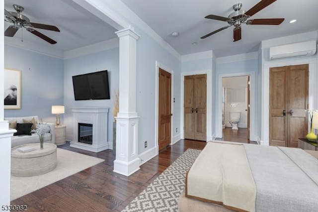 bedroom featuring decorative columns, ceiling fan, dark wood-type flooring, an AC wall unit, and connected bathroom