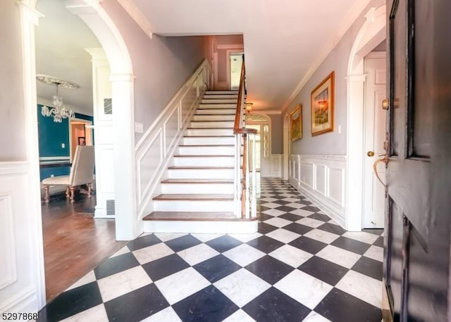 stairway with a notable chandelier and crown molding