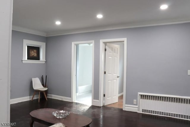 sitting room featuring dark hardwood / wood-style floors, radiator, and crown molding