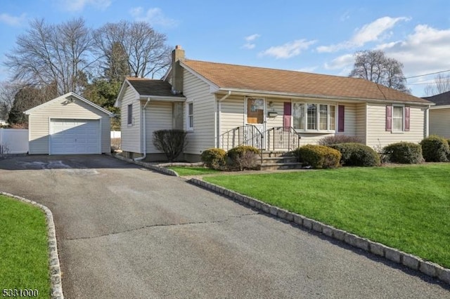 single story home featuring an outbuilding, a front yard, and a garage