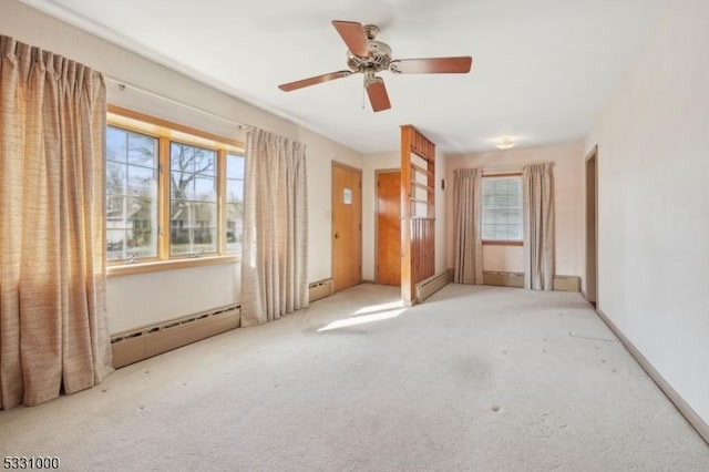 unfurnished room with light colored carpet, ceiling fan, a baseboard radiator, and a healthy amount of sunlight