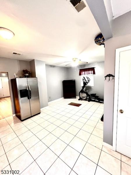 interior space with ceiling fan and light tile patterned floors