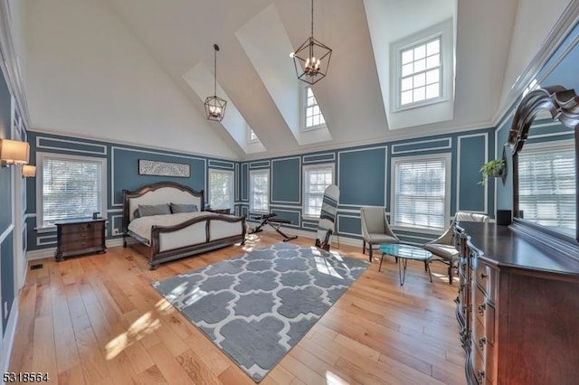 bedroom featuring a high ceiling and light wood-type flooring