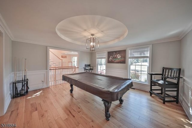 playroom featuring a raised ceiling, light hardwood / wood-style flooring, a notable chandelier, and billiards