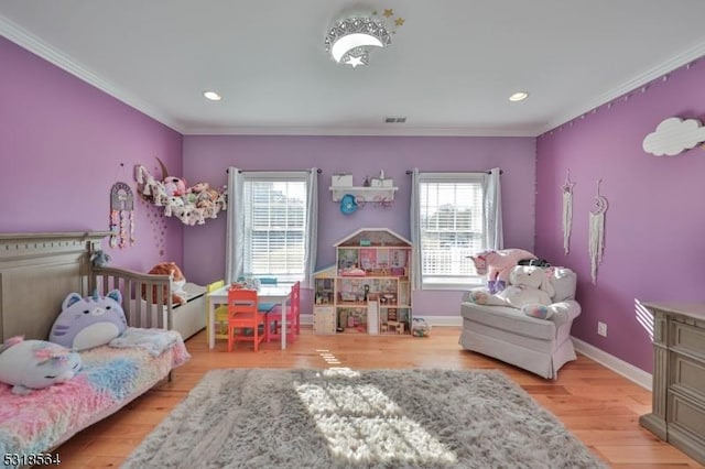 bedroom with light hardwood / wood-style floors, multiple windows, and ornamental molding