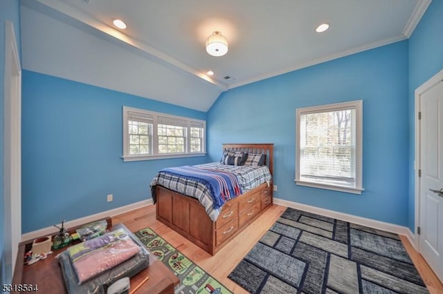 bedroom featuring light wood-type flooring, crown molding, and vaulted ceiling