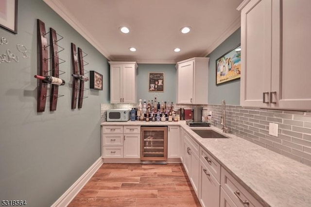 bar with white cabinets, backsplash, wine cooler, and ornamental molding